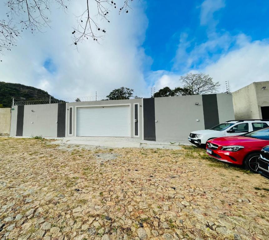a building with two white garage doors next to parked cars at Casa de Madeira 700 Serra Meruoca in Meruoca