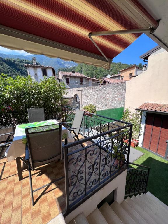 einen Balkon eines Hauses mit einem Tisch und Stühlen in der Unterkunft Casa Caterina 2 storey house, with a mountain view in Toscolano-Maderno