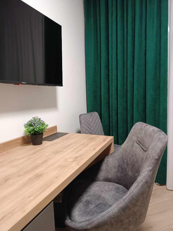 a desk with a chair and a television in a room at Adula - pokoje i apartamenty in Janów Lubelski