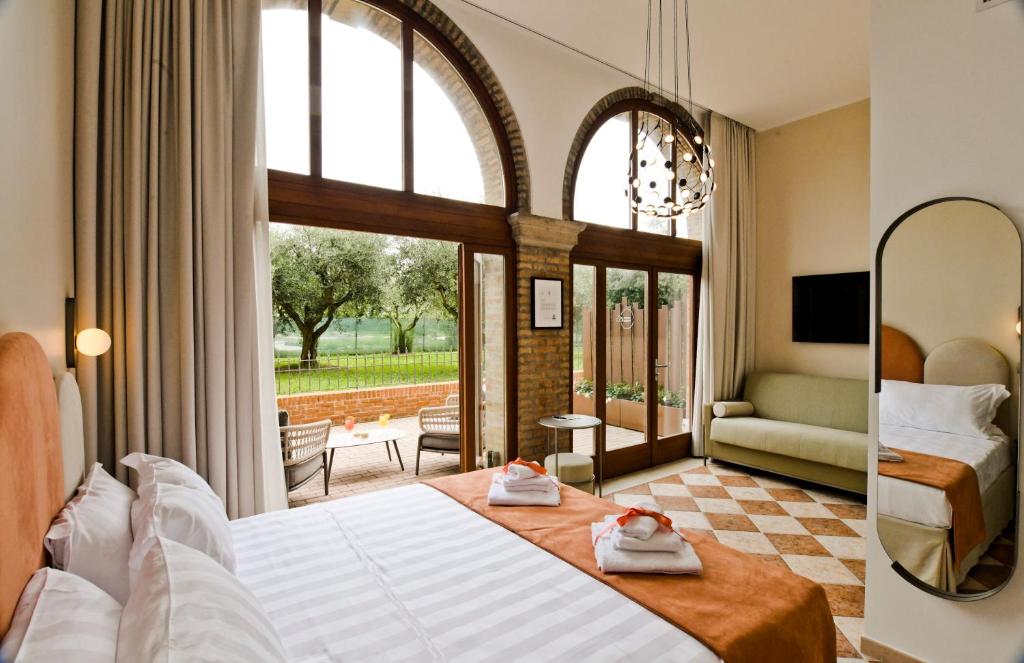 ヴェネツィアにあるMaison Boutique Al Redentoreのベッドと大きな窓が備わるホテルルームです。