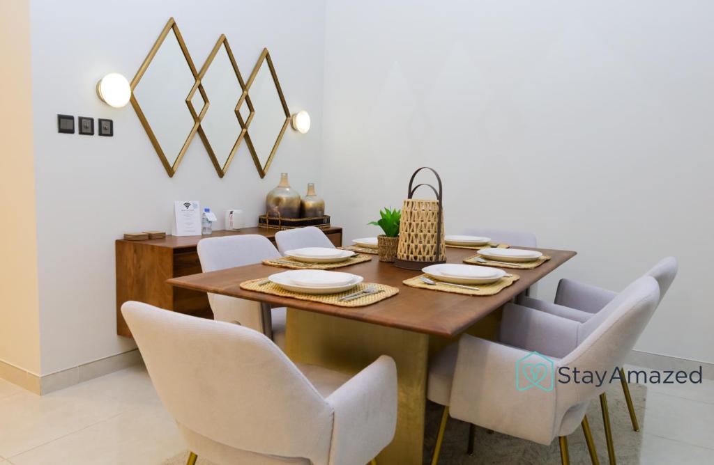 a dining room with a wooden table and chairs at Amazing 2 BR in The Polo Residence Meydan in Dubai