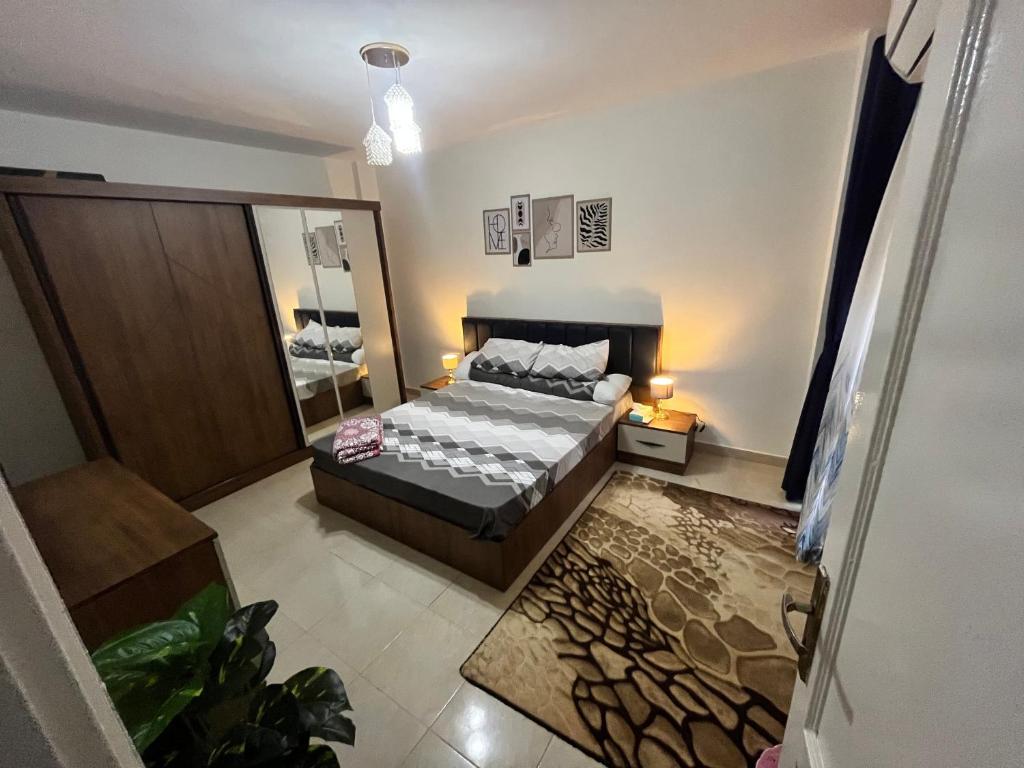 sypialnia z łóżkiem i dużym lustrem w obiekcie Madinaty Kian Al Deafah , New Cairo مدينتي w mieście Madinaty