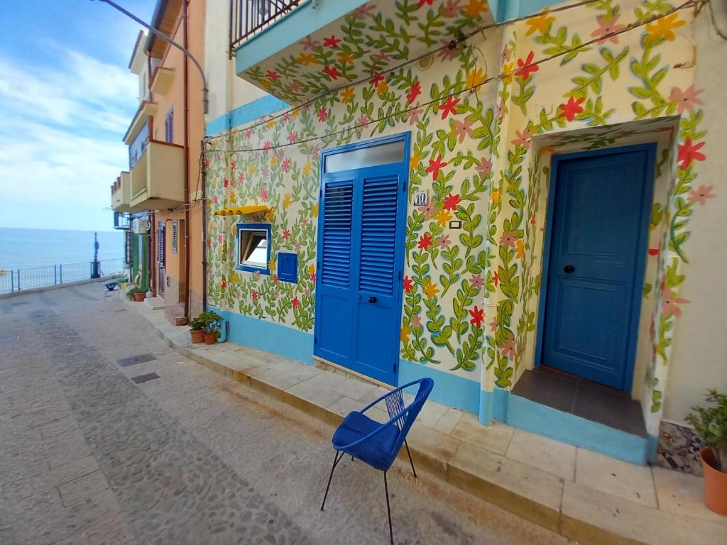 una sedia blu seduta su una strada accanto a un edificio di Casa Vacanze Marco Polo vista mare a Trappeto