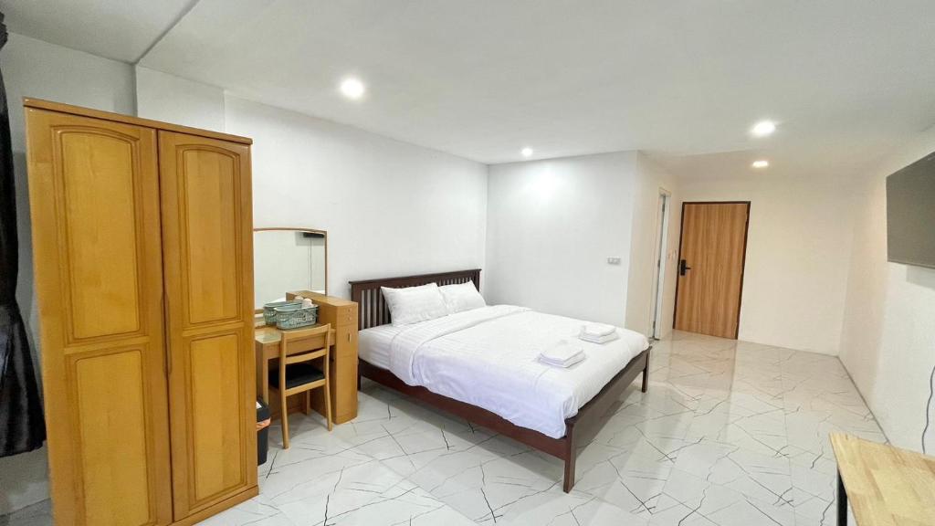 1 dormitorio con 1 cama y armario de madera en Little Seoul, en Chiang Mai