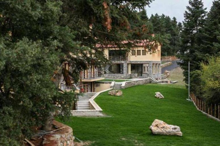 een groot huis met een tuin met groen gras bij Natura Hotel Vytina in Vytina