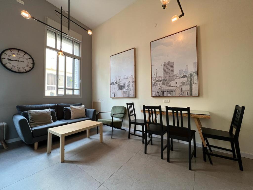 - un salon avec un canapé, une table et des chaises dans l'établissement 2Bedroom Suite Allenby Hotel, à Tel Aviv