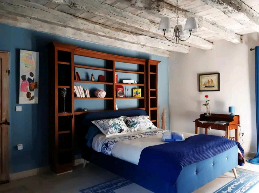 um quarto com uma cama e uma parede azul em Chez Sylvie em Excideuil
