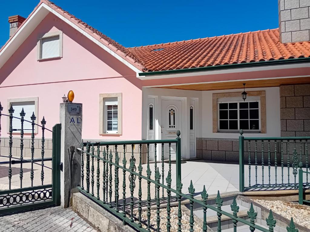 uma casa cor-de-rosa com uma cerca em PESO RIVER HOUSE em Melgaço