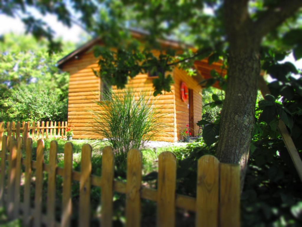 una recinzione di legno di fronte a una piccola casa di Csónakház a Tiszadob
