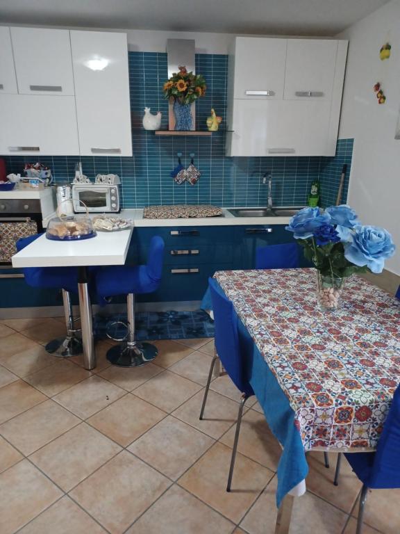 een keuken met blauwe kasten en een tafel met blauwe stoelen bij CASA ORCHIDEA in Carlentini
