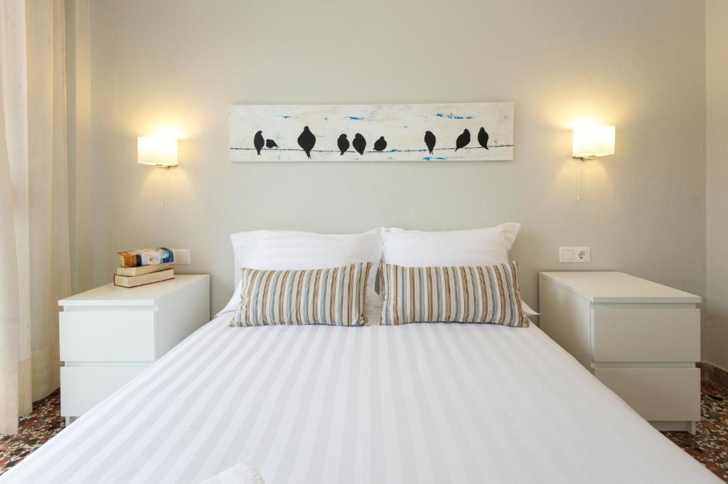 オリンピアキ・アクティにあるSonnenhausのベッドルーム1室(白い大型ベッド1台、ナイトスタンド2台付)