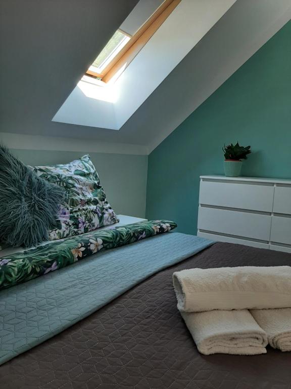 a bedroom with a bed and a skylight at Pokoje w Awokado z pięknymi widokami, Bałtów 184C in Bałtów