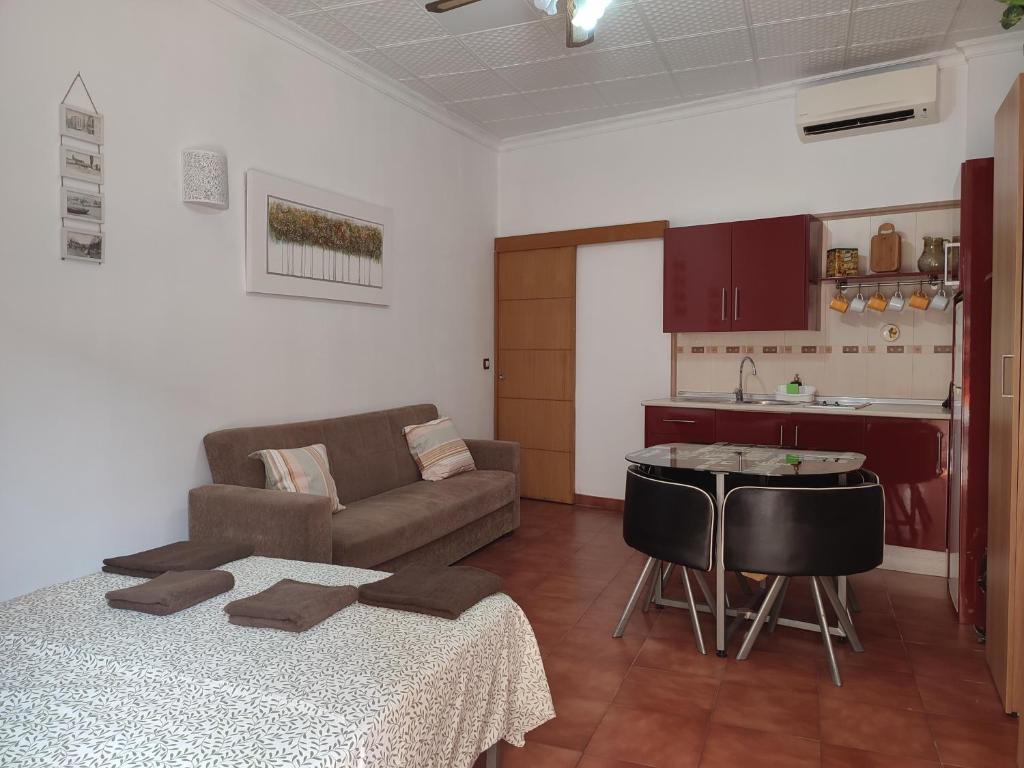 sala de estar con sofá, mesa y cocina en Sunny Holiday Studio, en Málaga