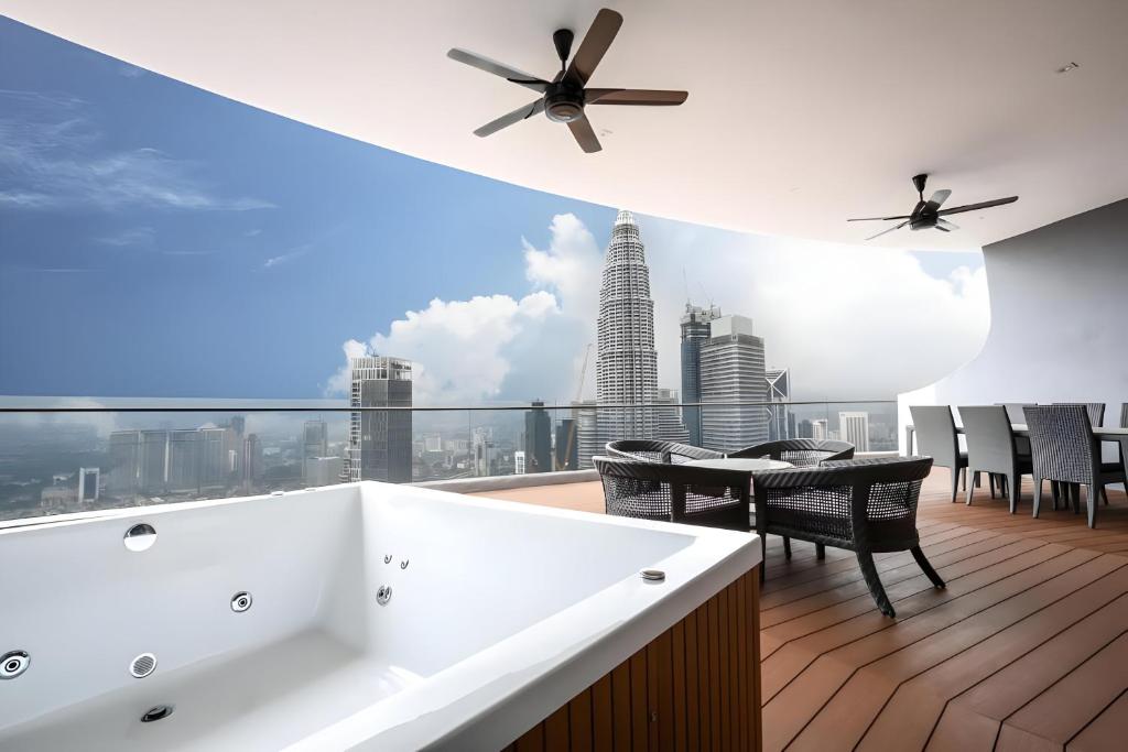 a balcony with a table and a view of the city at Vortex Klcc Penthouse Twins Tower View in Kuala Lumpur