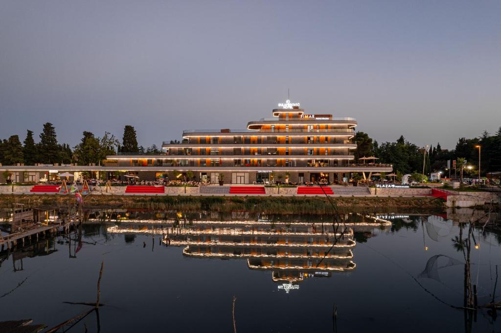 a large building with its reflection in the water at Dulamerovic Hotel in Ulcinj