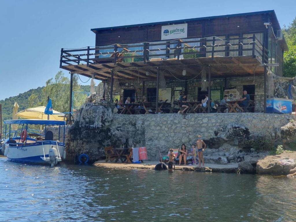 a group of people standing in the water near a boat at Apartmani Karučki krš in Podgorica