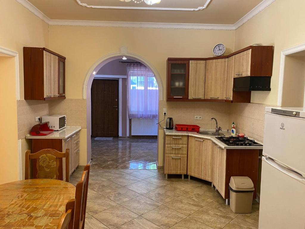 a kitchen with wooden cabinets and a table in it at Будинок для відпочинку Патріція in Berehove