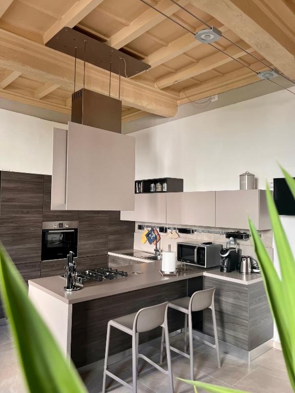 una cucina con armadi bianchi e 2 sedie di Dimora Boezio7, cozy and charming place in center with private parking a Pavia