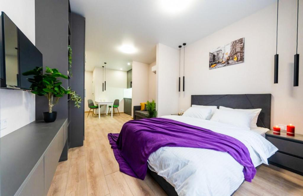 a bedroom with a large bed with a purple blanket at Шикарные апартаменты, Ревудского 40В, 3 мин пешком м Харьковская in Kyiv
