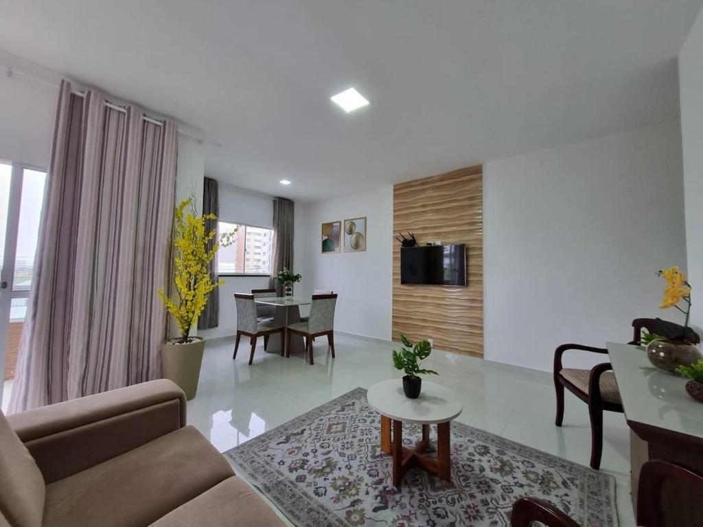 ein Wohnzimmer mit Sofa und Tisch in der Unterkunft Sobrado a 200m da Praia e Orla, 02 QTS com ar condicionado in Aracaju