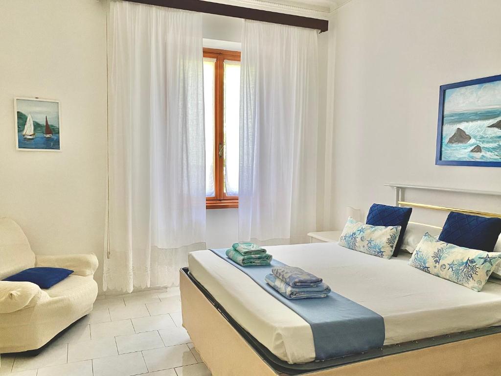a bedroom with a large bed and a chair at Ca del Mare - FREE Parking in La Spezia