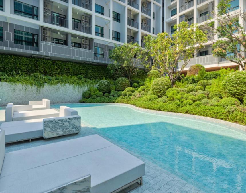a swimming pool in front of a building at DusitD2 Hua Hin - One bedroom with a beautiful view of the garden and pool in Hua Hin