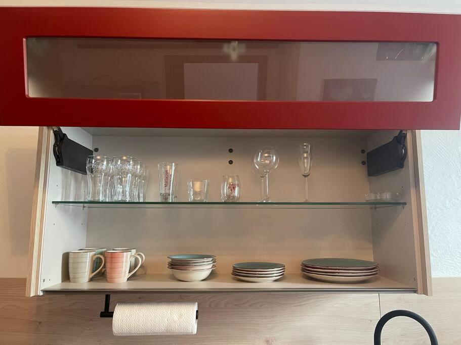 a cabinet with plates and glasses on a shelf at Großzügige Wohnung in Lüdenscheid