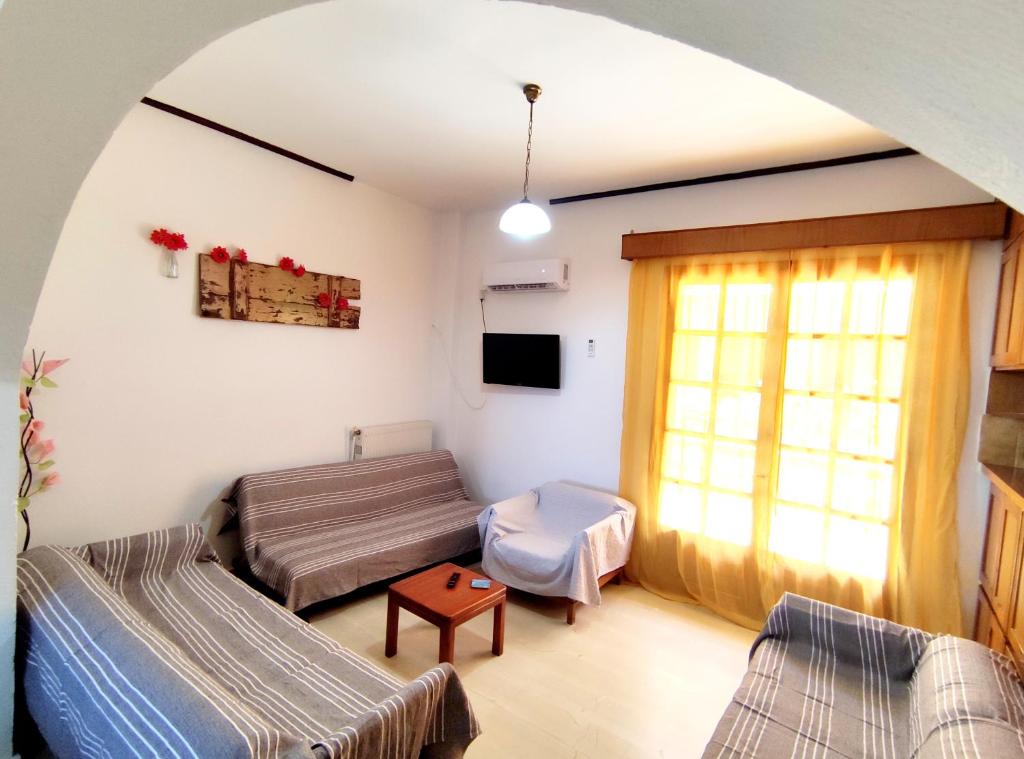 a living room with two beds and a window at Fouli Studios & Apartments in Rethymno Town