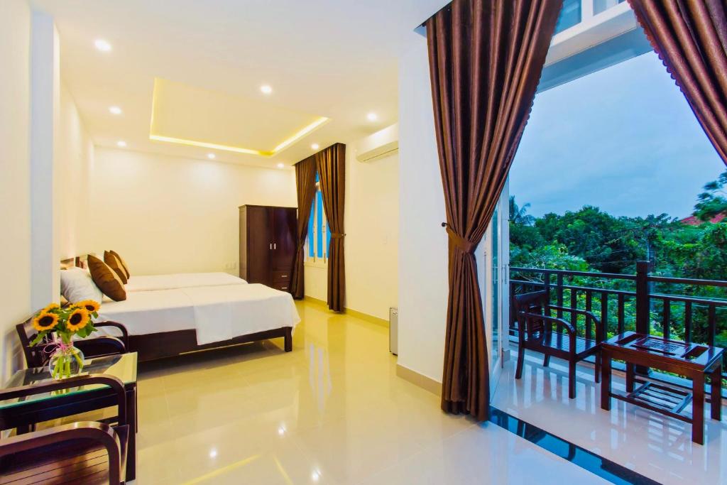 1 dormitorio con 1 cama y balcón en Pebble Homestay en Hoi An