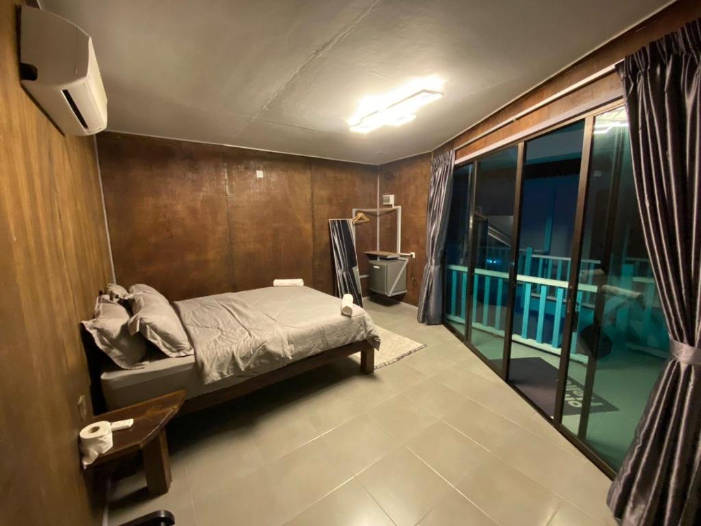 a bedroom with a bed and a large window at Pondok Beach Shack in Tioman Island