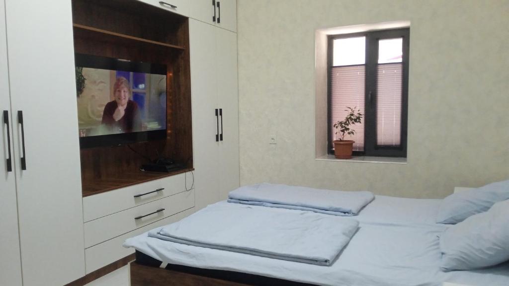 a bedroom with two beds and a flat screen tv at Begzod's house in Samarkand