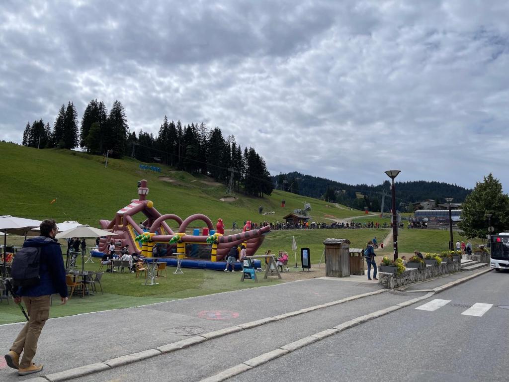 a person walking down a street next to a playground at GESPERE LE STELLA in Les Gets