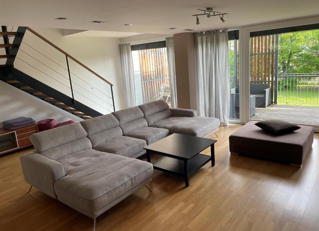 a living room with a couch and a ottoman at JD Apartment in Liptovský Mikuláš