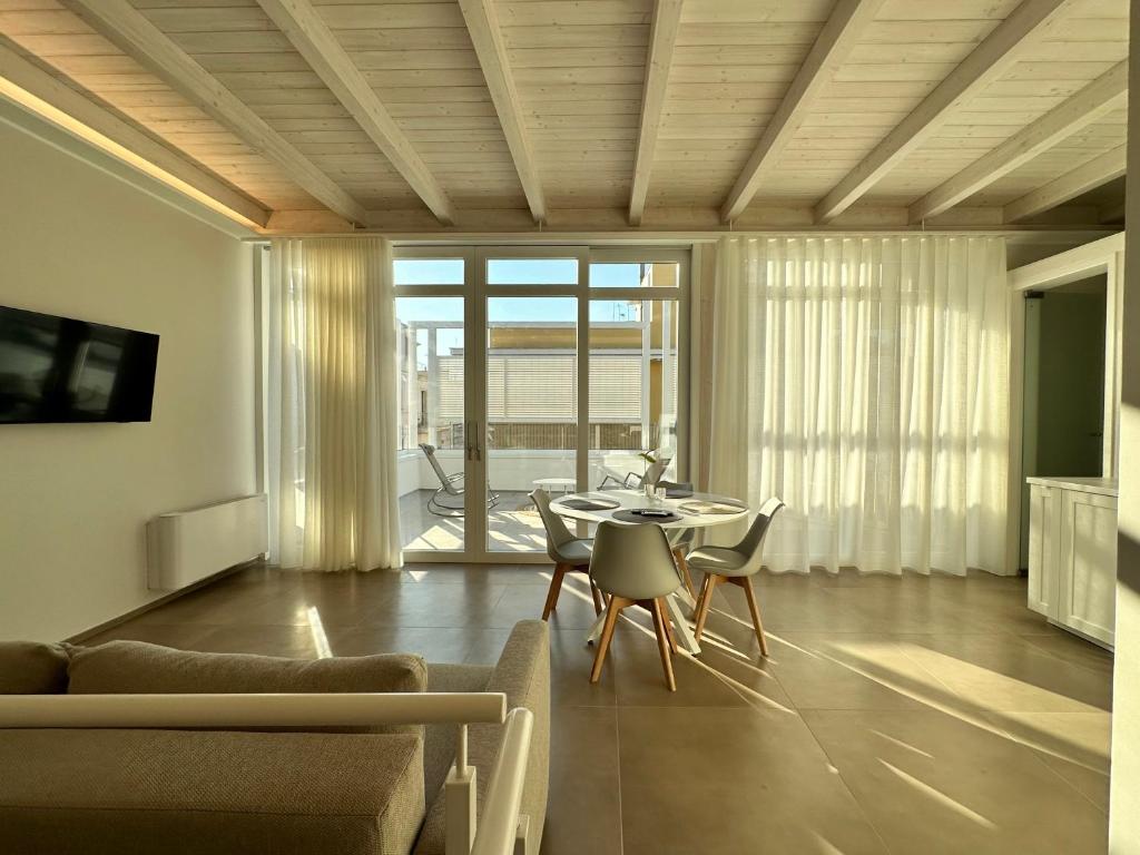 ein Wohnzimmer mit einem Tisch, Stühlen und einem Sofa in der Unterkunft Bottego24 Suite, Apartment & Terrace in Nardò