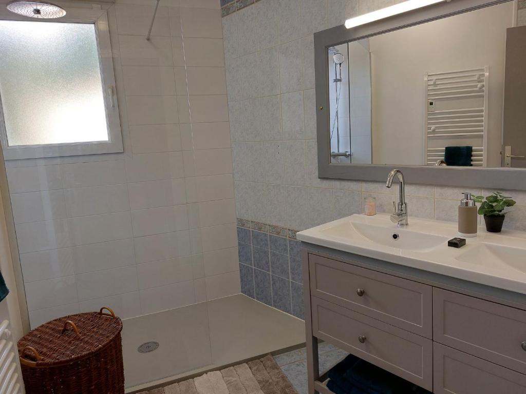 La salle de bains est pourvue d'un lavabo, d'une baignoire et d'un miroir. dans l'établissement villa bruyeres, à Thiers