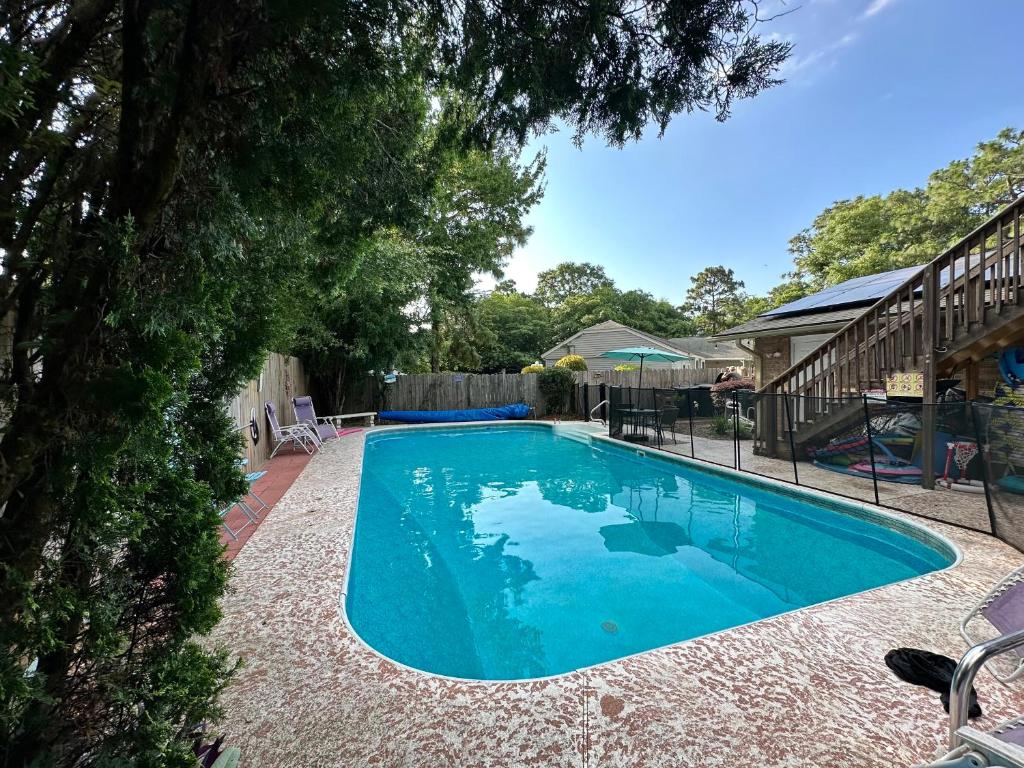 - une piscine d'eau bleue dans la cour dans l'établissement Pool-Spacious, Main House Haven, à Pensacola