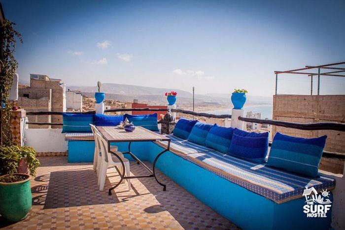 un sofá azul y una mesa en el balcón en Slimo, en Sidi Ifni