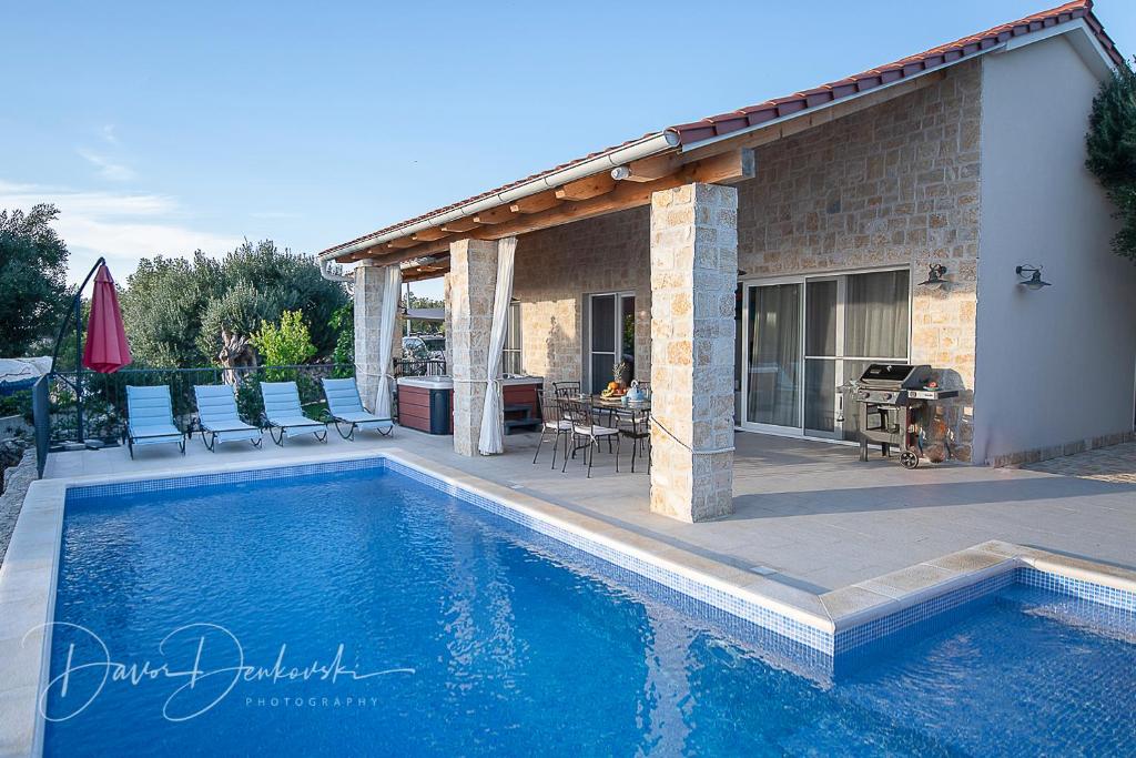 uma piscina em frente a uma casa em Island Villa Adriana with heated pool and sauna em Lun