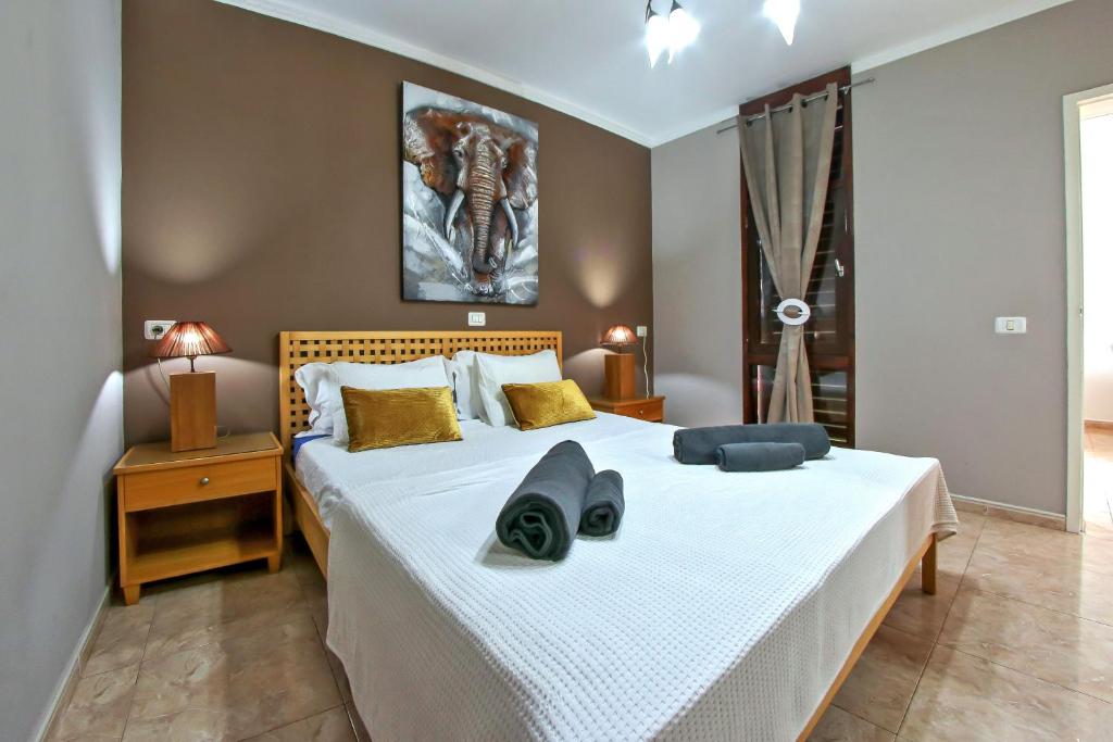 Exclusive 1 bedroom apartment with a Pool في أرونا: غرفة نوم مع سرير أبيض كبير في غرفة