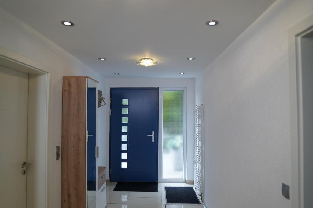 a hallway with a blue door and a window at Dreams im Erdgeschoss in Koetz 