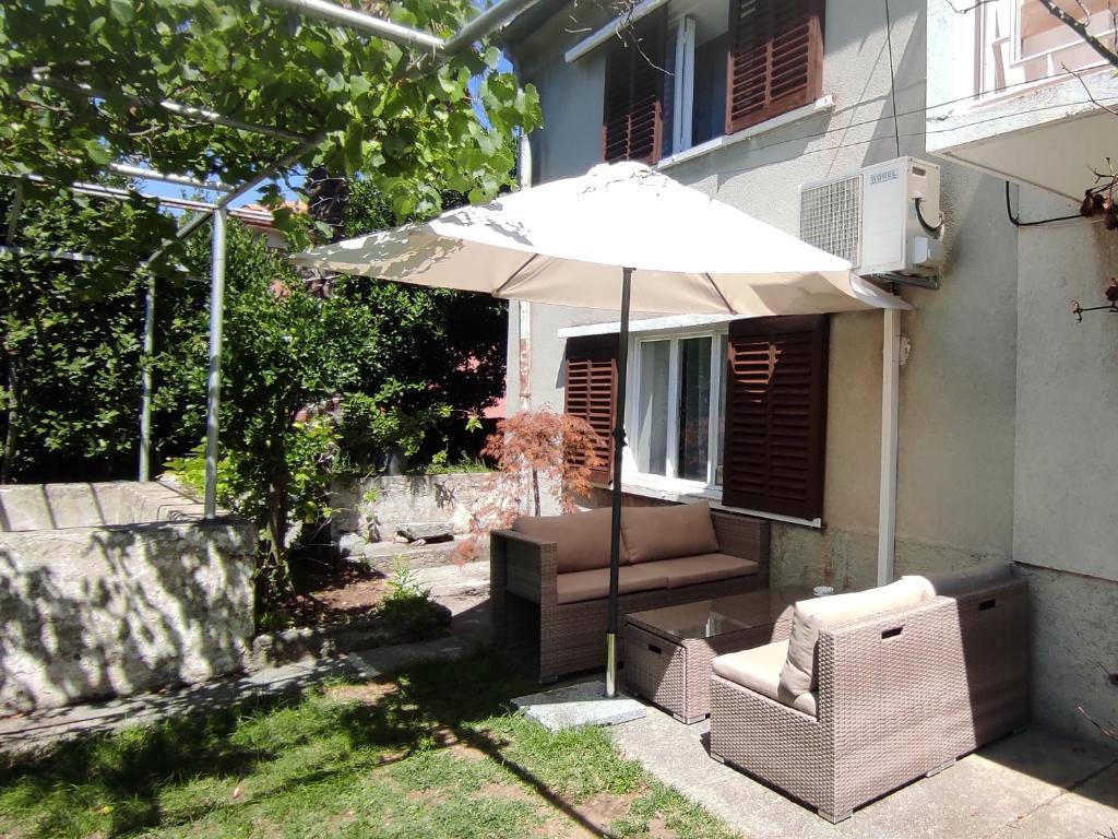 - une terrasse avec un parasol et des chaises dans la cour dans l'établissement Casa Flora, à Kraljevica