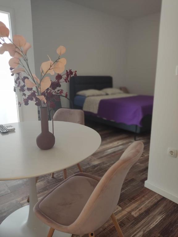 a room with a table and a vase with flowers on it at Studio apartman Mara in Imotski