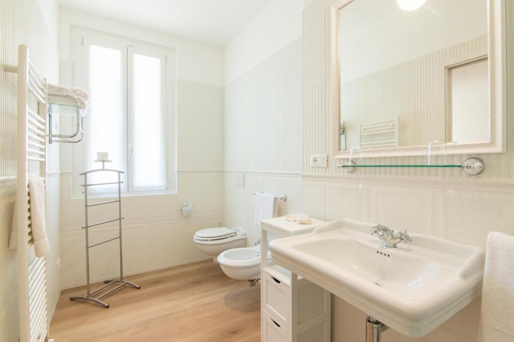 a white bathroom with a sink and a toilet at B&B Villa Eden jacuzzi pool in Domaso