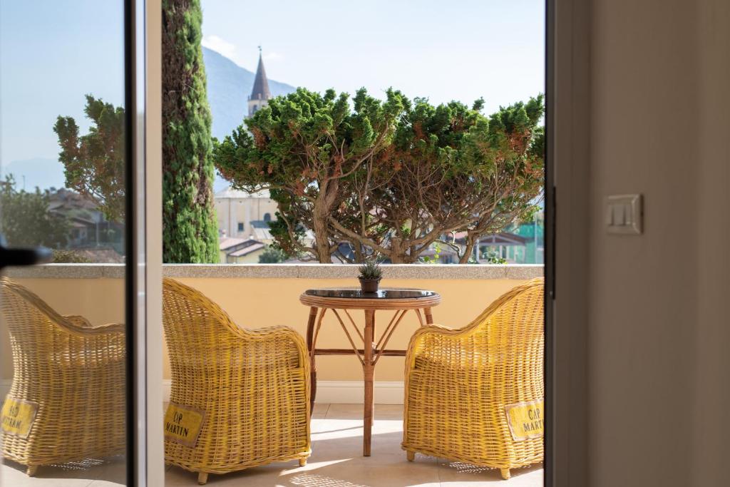 a balcony with a table and chairs and a tree at B&B Villa Eden jacuzzi pool in Domaso
