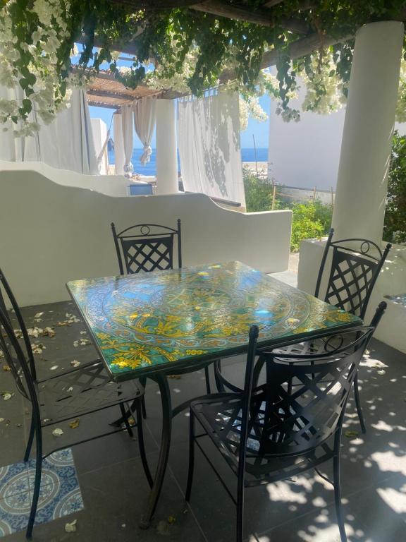 un tavolo in vetro e sedie su un patio di Casa Martha a Stromboli
