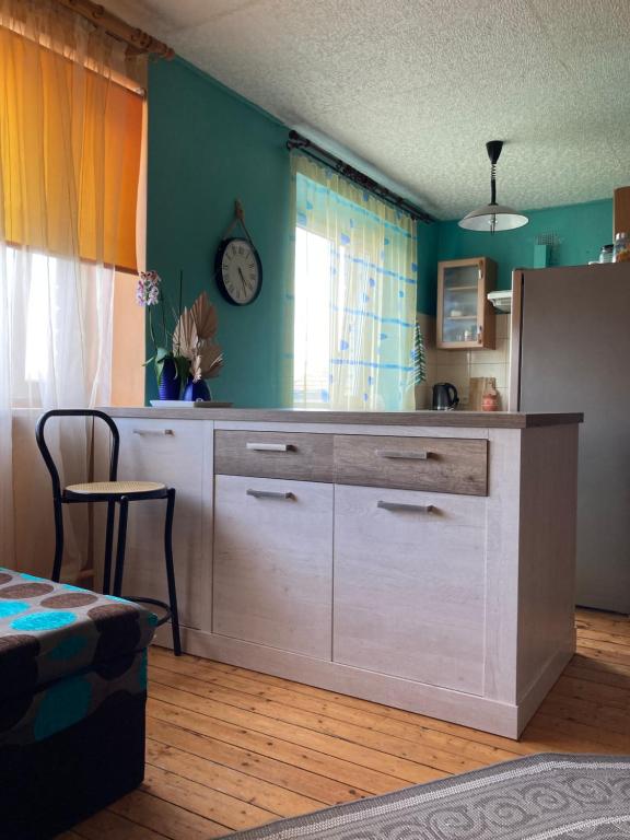 a kitchen with a large cabinet with a clock on the wall at Studio tipa dzīvoklis in Tukums