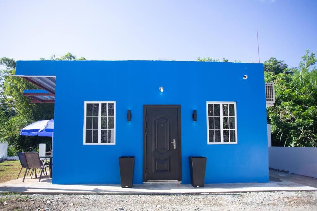 una casa azul con una puerta delante en Mary's Hill Tropical Oasis en Maryʼs Hill