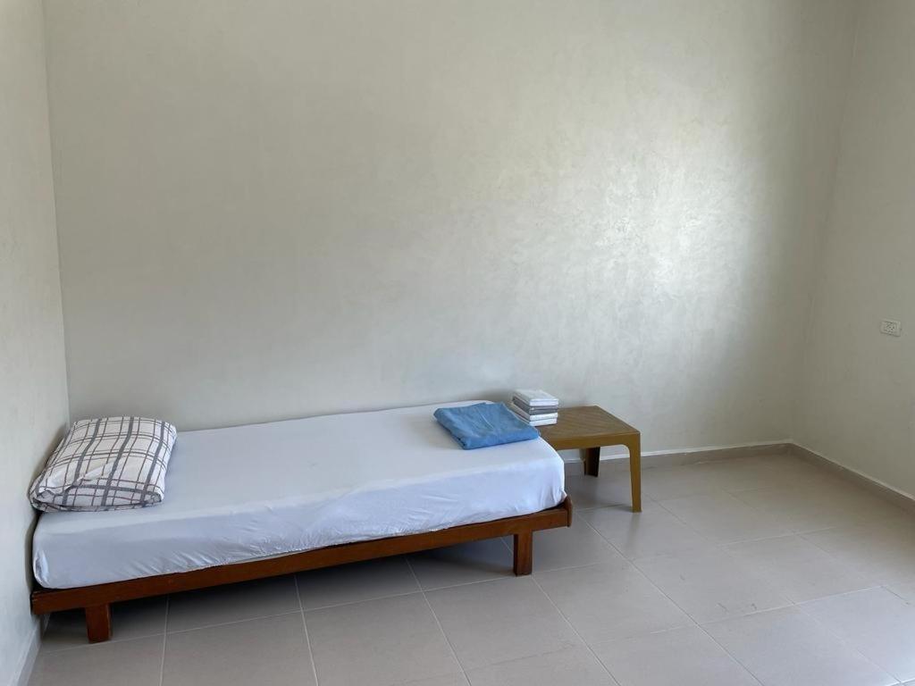 a small bed in a room with a table at Ain Sara Space in Hebron