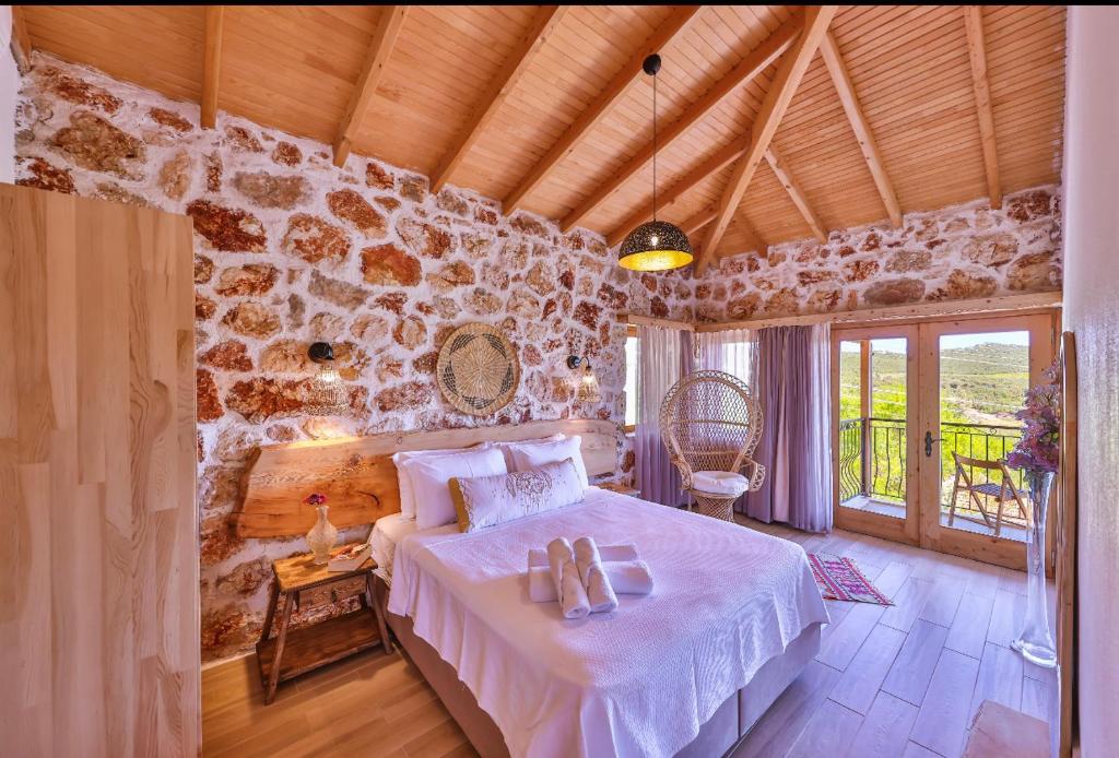 1 dormitorio con cama y pared de piedra en Melihaus en Cukurbag