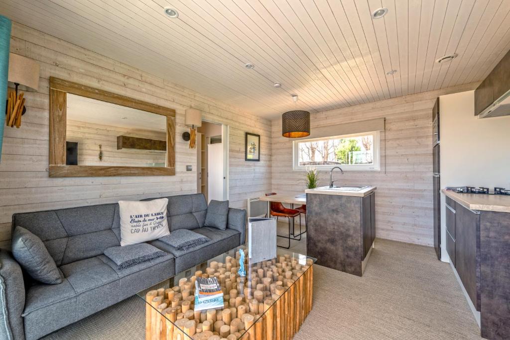 a living room with a couch and a kitchen at Le Theven in Sibiril